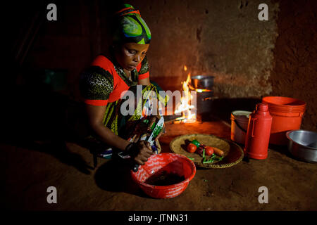 Mforo, Tanzania a village near Moshi, Tanzania. Solar Sister entrepreneur Fatma Mziray cooking dinner on her clean cookstove that uses wood. Fatma Mziray is a Solar Sister entrepreneur who sells both clean cookstoves and solar lanterns. Fatma heard about the cookstoves from a Solar Sister development associate and decided to try one Stock Photo