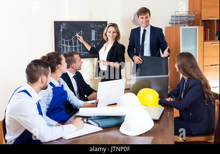Successful architectural engineers discussing business project and smiling indoors Stock Photo
