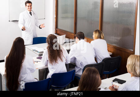 Multinational students and positive professor having discussion at medical faculty Stock Photo