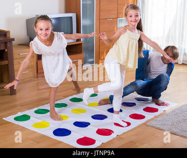 Two of happy children playing at twister in house. Brother and sister ...