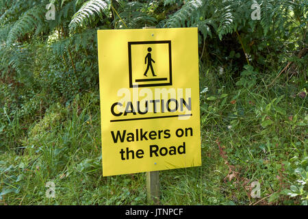 caution walkers on the road sign in a popular tourist walking route in northern ireland Stock Photo