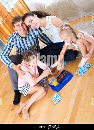 Little girls with parents trying chances at lotto game Stock Photo