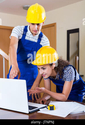 Successful team of builders brainstorming and smiling indoors Stock Photo