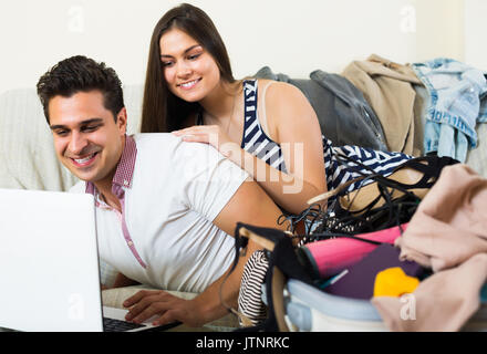 Smiling young couple preparing for honeymoon and making planning list at home Stock Photo
