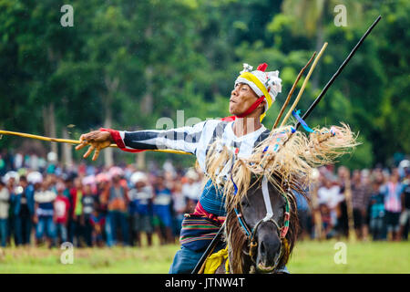 Man throwing spear and riding horse at Pasola Festival, Sumba island, Indonesia Stock Photo