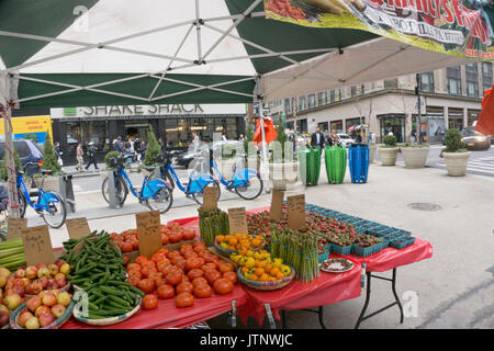 farmers market with luscious spring produce shares partly closed section Broadway between 36th & 35th street with Citibike station & 3 recycling cans Stock Photo