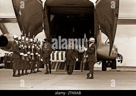 An Air Force honor guard stands at attention while the transfer case of an MIA from North Vietnam is removed from a C-141 Starlifter aircraft. Stock Photo