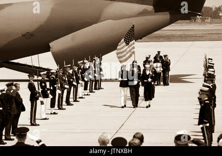 Preceded by the National Color Guard and members of the clergy, a joint services casket team carries the casket of the Unknown Serviceman of the Vietnam Era past a joint services honor cordon during the arrival ceremony on the flight line.  The Unknown was brought from Travis Air Force Base, California, to Andrews aboard the C-141B Starlifter aircraft in the background. Stock Photo