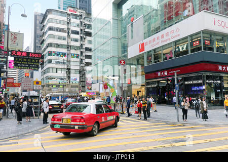 HONG KONG, CHINA - APRIL 27; Busy street in Hong Kong with traffic and many pedestrians crossing the road in Hong Kong, China - April 27, 2017: Tradit Stock Photo