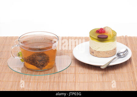 Lime cheesecake on plate and tea in glass cup Stock Photo