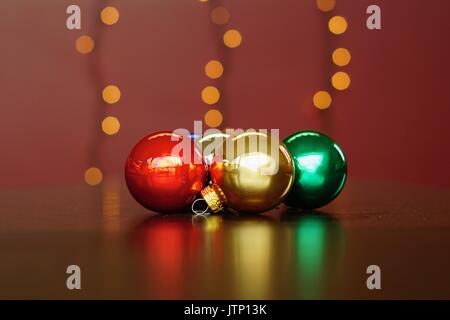 Grouping of multi coloured Christmas balls with blurred lights in background Stock Photo