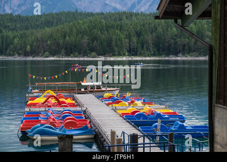 Colourful pedal boats moored at the pier on lake Eibsee, Bavaria, Germany Stock Photo