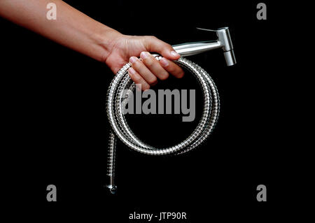 bidet shower in hand  isolated on black background Stock Photo