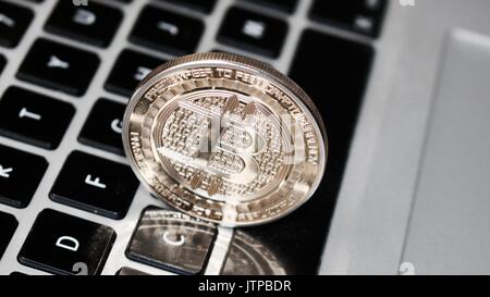 Digital currency physical metal bitcoin coin on the keyboard. Bitcoin security. Stock Photo