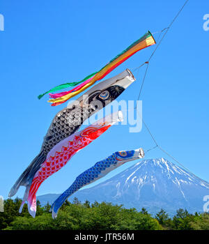 Colourful Koinobori Carp Kites against a clear blue sky at the Asagiri Highlands with Mt. Fuji in the background in Japan Stock Photo