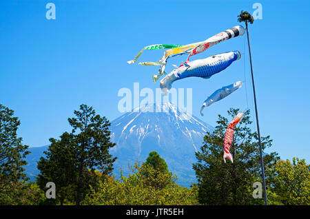 Colourful Koinobori Carp Kites against a clear blue sky at the Asagiri Highlands with Mt. Fuji in the background in Japan Stock Photo