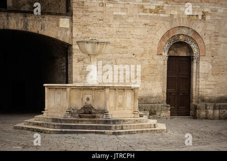 Medieval fountain and San Silvestro Church façade in the main square of the town of Bevagna in Umbria (Italy). Stock Photo
