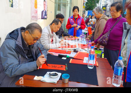 HONG KONG, CHINA - JANUARY 26, 2017: Unidentified people writting wisshes over a red paper contain meaning for Chinese New Year wishes in Hong Kong Stock Photo