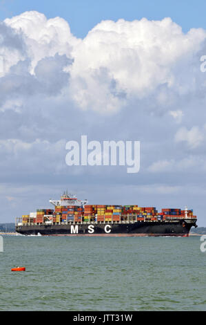 a large container ship leaving or entering Southampton docks imports and exports by sea and containerisation products ready for distribution by rail Stock Photo