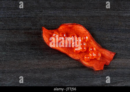 Salmon caviar with red chips on a black wood Red caviar on potato chips, Stock Photo