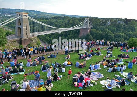 Bristol, UK. 10th Aug, 2017. UK Bristol. Thousands of people sitting on the grass by the observatory tower over looking World famous Clifton Suspension Bridge, hoping to get a wonderful view of the balloons as they lift off from Ashton Court Estate on the first evening of the Event. Mandatory Byline Credit: Robert Timoney/Alamy Live News Stock Photo