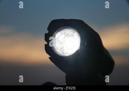 Bicycle Light Illuminated on Handlebars Against Sunset Stock Photo