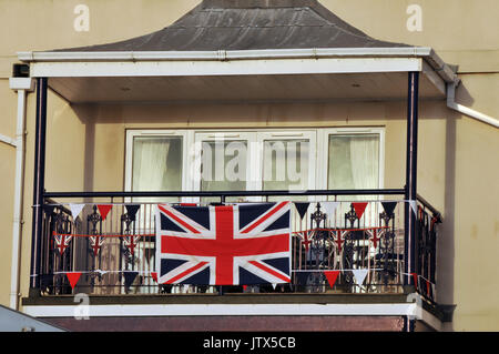 a balcony in cowes on the isle of wight decorated with union jacks and flags in a patriotic fashion. Patriotism and red white and blue colours. Stock Photo