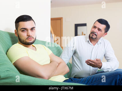 Two male adults arguing about something indoors after quarrel Stock Photo