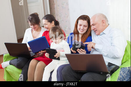 happy multigeneration family using few laptops in home Stock Photo