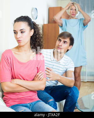Young man comforting girl after domestic conflict with mother Stock Photo