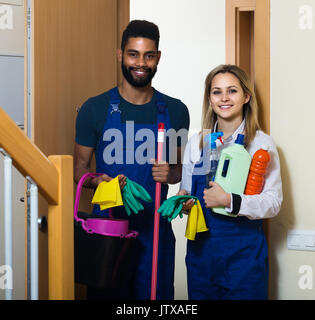 african american cleaners in uniform with cleaning supplies looking at  camera isolated on white Stock Photo - Alamy