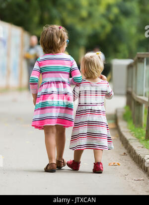 Rear view of two children at street Stock Photo