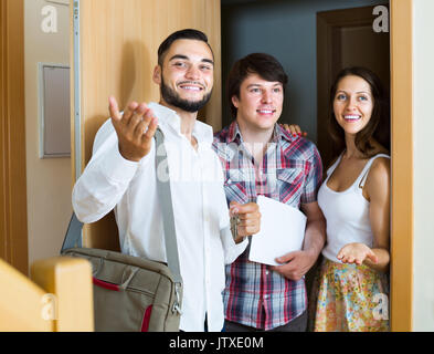 realtor showing new apartment to smiling american couple Stock Photo