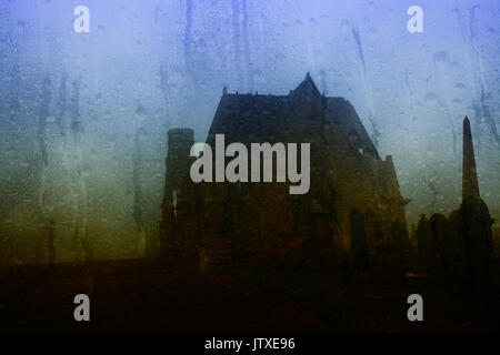 Looking through a misty window with raindrops at an old cemetery in the rain Stock Photo