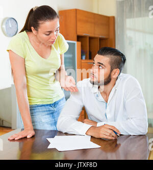 Worried upset pair discussing problems with contract at home Stock Photo