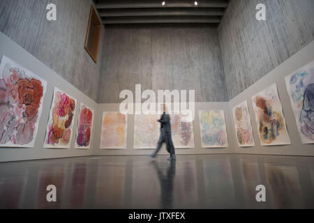A visitor walks past artist Barbara Nicholls new watercolour piece 'sedmientary flow' on display on the 4th floor at the New Walsall Art Gallery, Walsall, West Midlands. Stock Photo