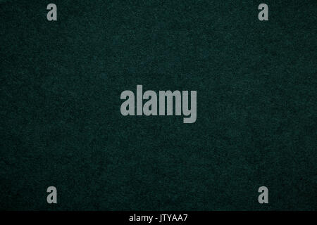 Texture of old dark green paper background, closeup. Structure of dense emerald cardboard. Stock Photo