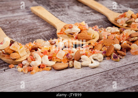 Close up of sweet dried fruits and roasted nuts in wooden spoon Stock Photo