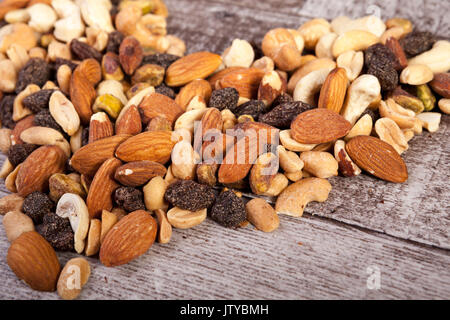 Mix of healthy raw nuts on wooden background Stock Photo