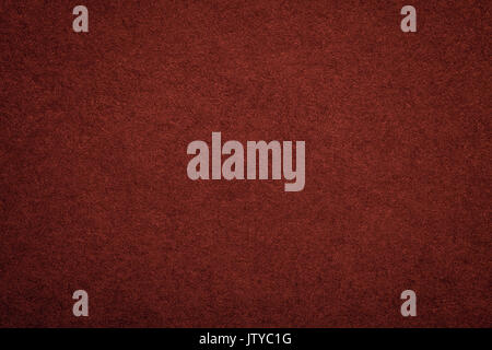 Texture of old dark red paper background, closeup. Structure of dense maroon cardboard. Stock Photo
