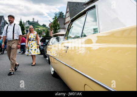 Vintage Car Festival 'Golden Oldies', Woman dressed in fifties look and a yellow vintage car on the main street below the castle. Stock Photo