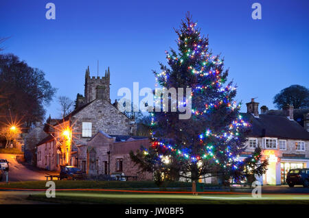 A Christmas tree and festive lights embellish the centre of Hartington, a scenic village in the Peak District,Derbyshire,England UK - December Stock Photo