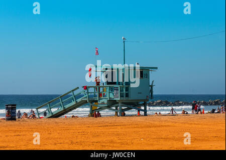 Lifeguard Tower with woman lifeguard on duty at the beach of Santa Monica. Baywatch tower with colorful sky and beach. Stock Photo