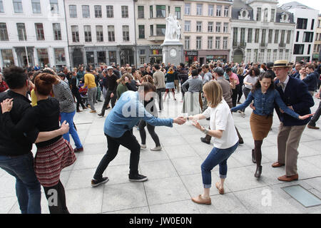 Couples swing dance in front of The Royal Dutch Theatre in Gent Belgium  located on Sint-Baafsplein Square between St. Bavo's Cathedral and the Belfry Stock Photo