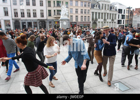 Couples swing dance in front of The Royal Dutch Theatre in Gent Belgium  located on Sint-Baafsplein Square between St. Bavo's Cathedral and the Belfry Stock Photo