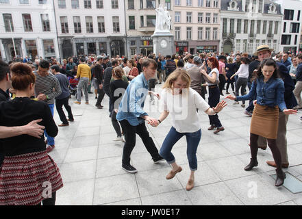 Couples swing dance in front of The Royal Dutch Theatre in Gent Belgium  located on Sint-Baafsplein Square between St. Bavo's Cathedral and the Belfry Stock Photo