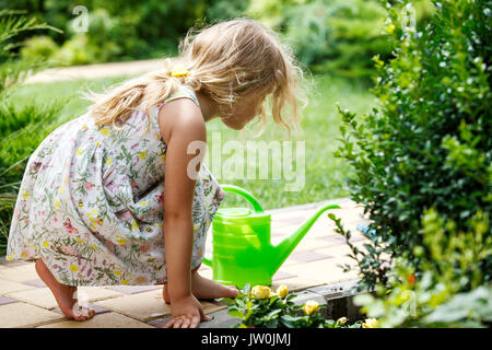 Cute little girl watering plants in the garden. Stock Photo