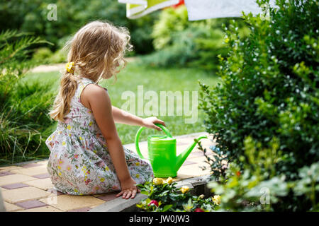 Cute little girl watering plants in the garden. Stock Photo