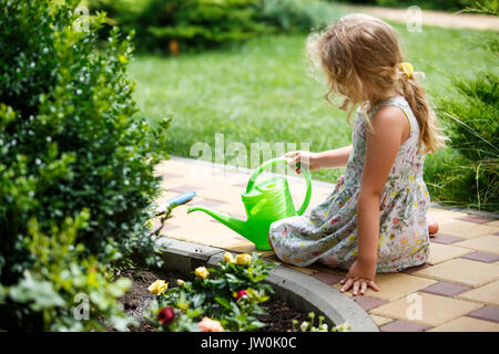 Cute little girl watering plants in the garden. Stock Photo