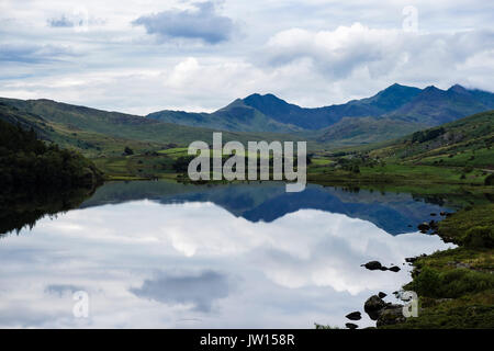 Calm waters of Llynnau Mymbyr lakes reflecting Snowdon horseshoe in Snowdonia National Park (Eryri). Capel Curig, North Wales, UK Stock Photo